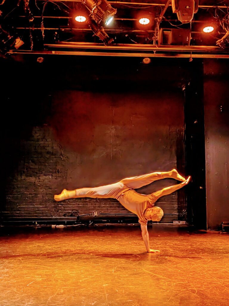 Dancer balanced on one hand, legs in a split